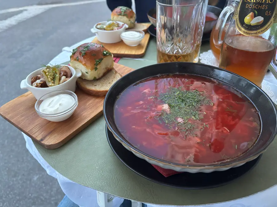 Borschtsch mit Dill, daneben Pampuschky mit Knoblauch und Sauerrahm