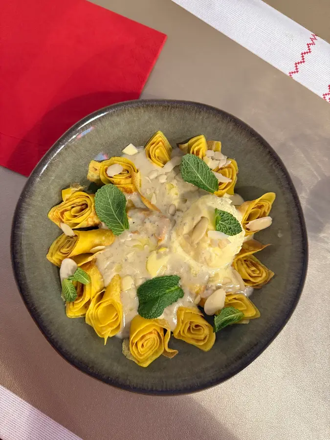 Palatschinken zu Rosen gerollt, mit Vanillesauce, Mandeln, Minze und Eis